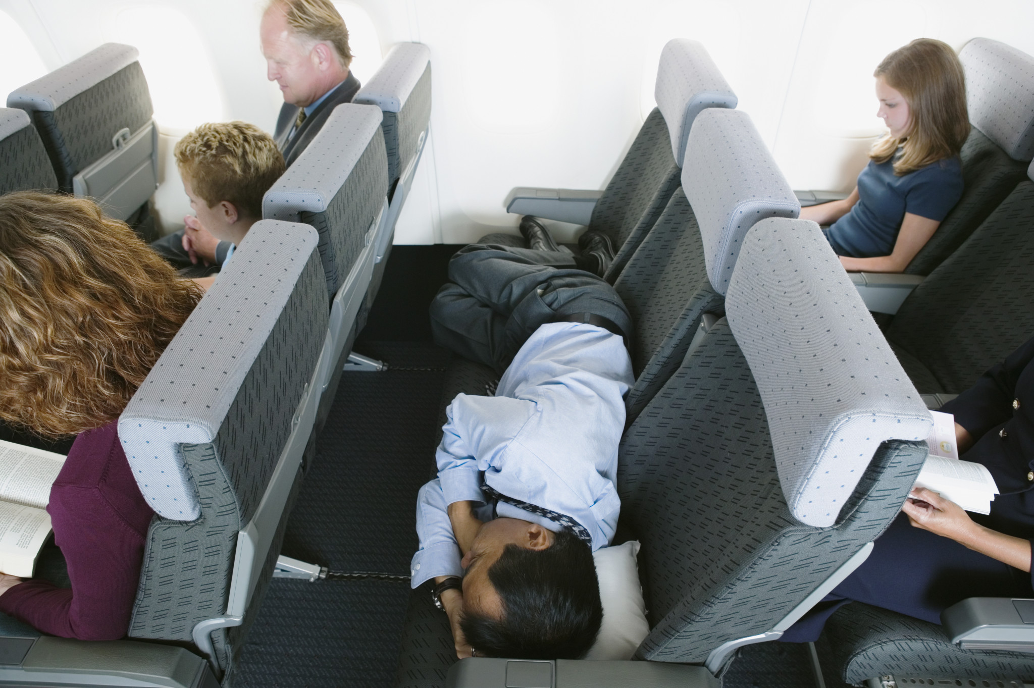 Три места свободны. Спать в самолете. Сиденья в самолете. Спящие пассажиры в самолете.